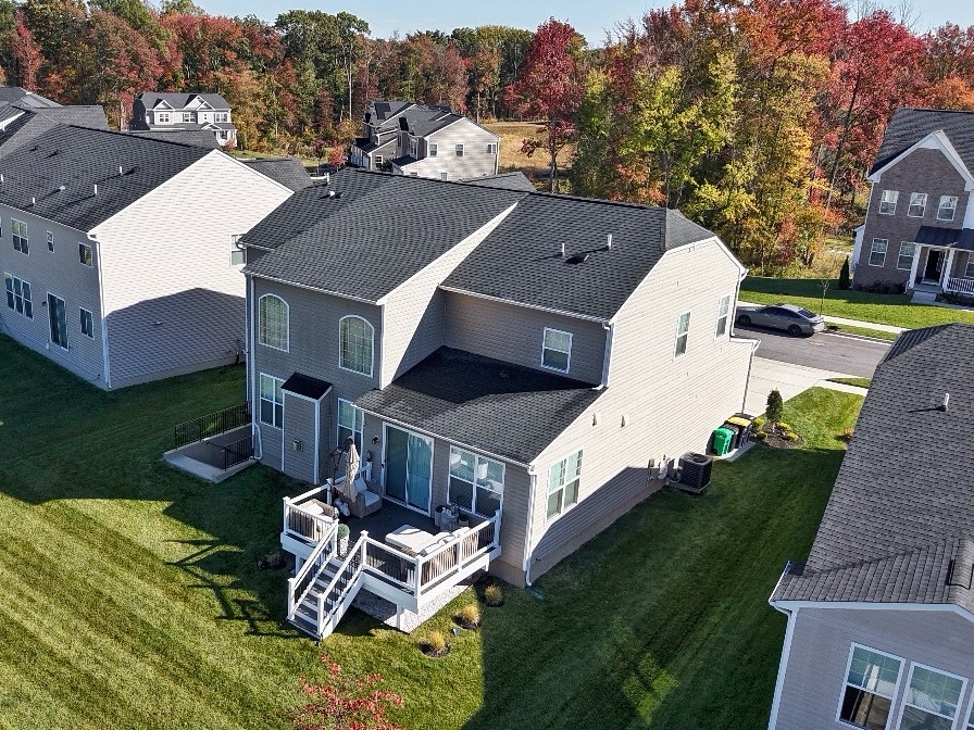 Back deck and patio of the Glenn Dale home with lawn and autumn trees